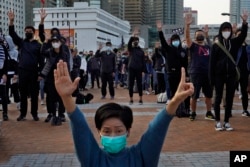 FILE - Protesters raise five demands gestures during a rally in Hong Kong, Jan. 12, 2020.