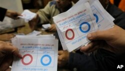 Election workers count ballots ticked "agree", at the end of the second, final day of a key referendum on a new constitution, inside a polling station in Cairo, Egypt, Wednesday, Jan. 15, 2014. The vote is a milestone in a military-backed political roadma