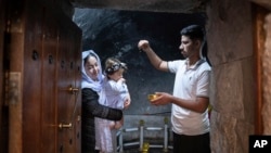 A child is baptized in Lalish, the Yazidi's most holy temple, in the Shekhan district of the Kurdistan region of Iraq, June 24, 2024.