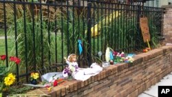 Items are placed at a makeshift memorial, the scene where a police officer fatally shot Justine Damond, of Sydney, Australia, July 18, 2017, in Minneapolis. 