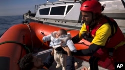 Un bébé de deux mois, en provenance de Libye, est retiré d'un navire de la Garde côtière libyenne et embarqué dans canot pneumatique de l'ONG espagnole Proactiva Open Arms, après avoir été sauvé d'une barque en bois hors de contrôle en Méditerranée, à env