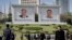 people walk beneath portraits of late leaders, Kim Il Sung, left, and Kim Jong Il, in Pyongyang, North Korea, April 18, 2017.