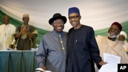 Nigeria's President Goodluck Jonathan, center-left, and President-elect Gen. Muhammadu Buhari, center-right, hug and shake hands after signing a renewal of their pledge to hold peaceful "free, fair, and credible" elections, at a hotel in the capital. 