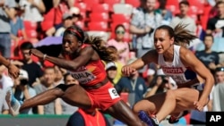 La Burkinabè Marthe Koala, à gauche, en compétition avec la Britannique Jessica Ennis-Hill lors des Championnats du monde d’athlétisme au à Beijing, Chine, 22 août 2015.