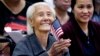 Hong Inh waves an American flag and smiles after taking the oath to become a United States citizen at the Los Angeles Convention Center, in Los Angeles, California, Aug. 22, 2017.