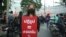 Baifern Benjama, a pro-democracy protester, holds a sign reading "Reform = make it better," at a Bangkok street protest. (Vijitra Duangdee/VOA)