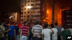 People look at a fire that erupted inside a six-story hotel called Andalusia in the populous Ataba neighborhood in Cairo, Egypt, May 9, 2016. 