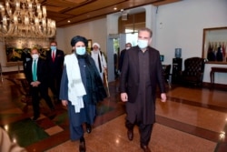 FILE - Pakistan's Foreign Minister Shah Mahmood Qureshi, right, and Mullah Abdul Ghani Baradar, head of a Taliban political team, arrive at the Foreign Ministry for talks, Islamabad, Dec. 16, 2020. (Pakistan Ministry of Foreign Affairs photo)