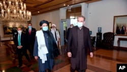 FILE - Pakistan's Foreign Minister Shah Mahmood Qureshi, right, and Mullah Abdul Ghani Baradar, head of a Taliban political team, arrive at the Foreign Ministry for talks, Islamabad, Dec. 16, 2020. (Photo provided by Pakistan's Ministry of F. Affairs) 