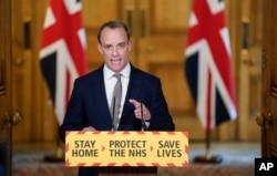In this photo made available by 10 Downing Street, Britain's Foreign Secretary Dominic Raab gestures during a coronavirus media briefing at 10 Downing Street, in London, April 16, 2020.