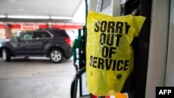 FILE - An "out of service" bag covers a gas pump as cars line up at a Circle K gas station near uptown Charlotte, N.C., May 11, 2021, following a ransomware attack that shut down the Colonial Pipeline, a major East Coast gasoline provider. 