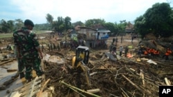 Regu penyelamat menlakukan pencarian korban di desa yang terkena dampak paling parah akibat longsor dan banjir bandang di Garut, Jawa Barat, 21 September 2016 (AP Photo).