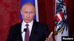 Russia's President Vladimir Putin gestures during a joint news conference with Austria's President Alexander Van der Bellen in Vienna, Austria June 5, 2018.