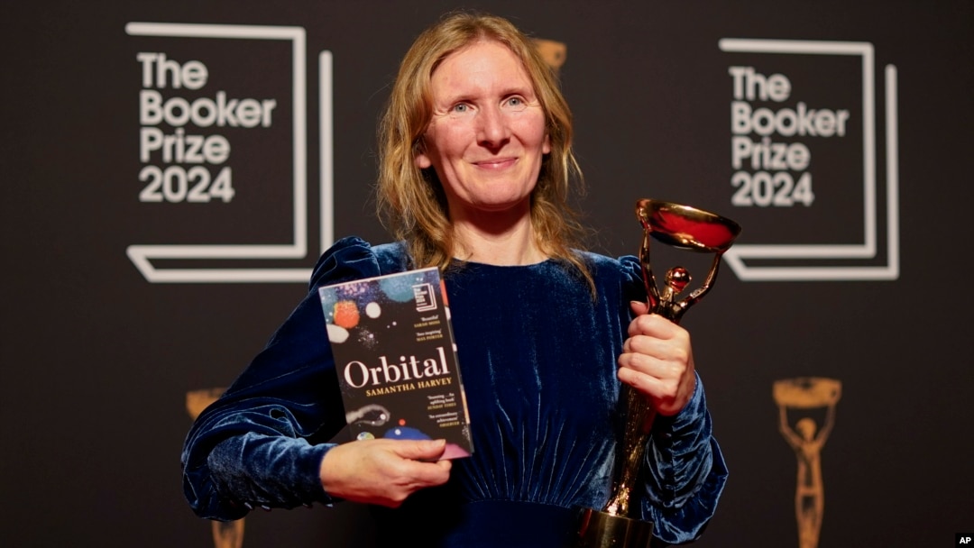Samantha Harvey poses with the trophy and her book "Orbital" after winning the Booker Prize award 2024, in London, Nov. 12, 2024. 