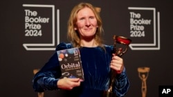 Penulis Samantha Harvey berpose dengan trofi dan novelnya "Orbital" setelah meraih penghargaan Booker Prize 2024 di London, pada 12 November 2024. (Foto: AP/Alberto Pezzali)