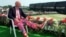 FILE - Tennis commentator Bud Collins, known for his flashy attire, displays a pair of brightly colored trousers as he sits overlooking the outside courts at Wimbledon, England, June 30, 1993. Collins died Friday at his home in Massachusetts; he was 86.