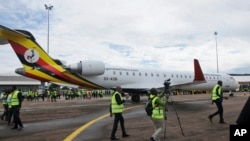 FILE - In this Tuesday, April 23, 2019 file photo, cameramen film at a ceremony to mark the arrival of two CRJ-900 jets from Canadian aerospace company Bombardier, at the airport in Entebbe, Uganda.