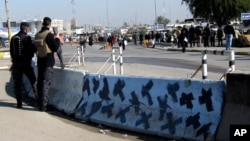 Iraqi security forces stand guard at the site of a bomb attack in Baghdad, Iraq, Sunday, Jan. 12, 2014. 