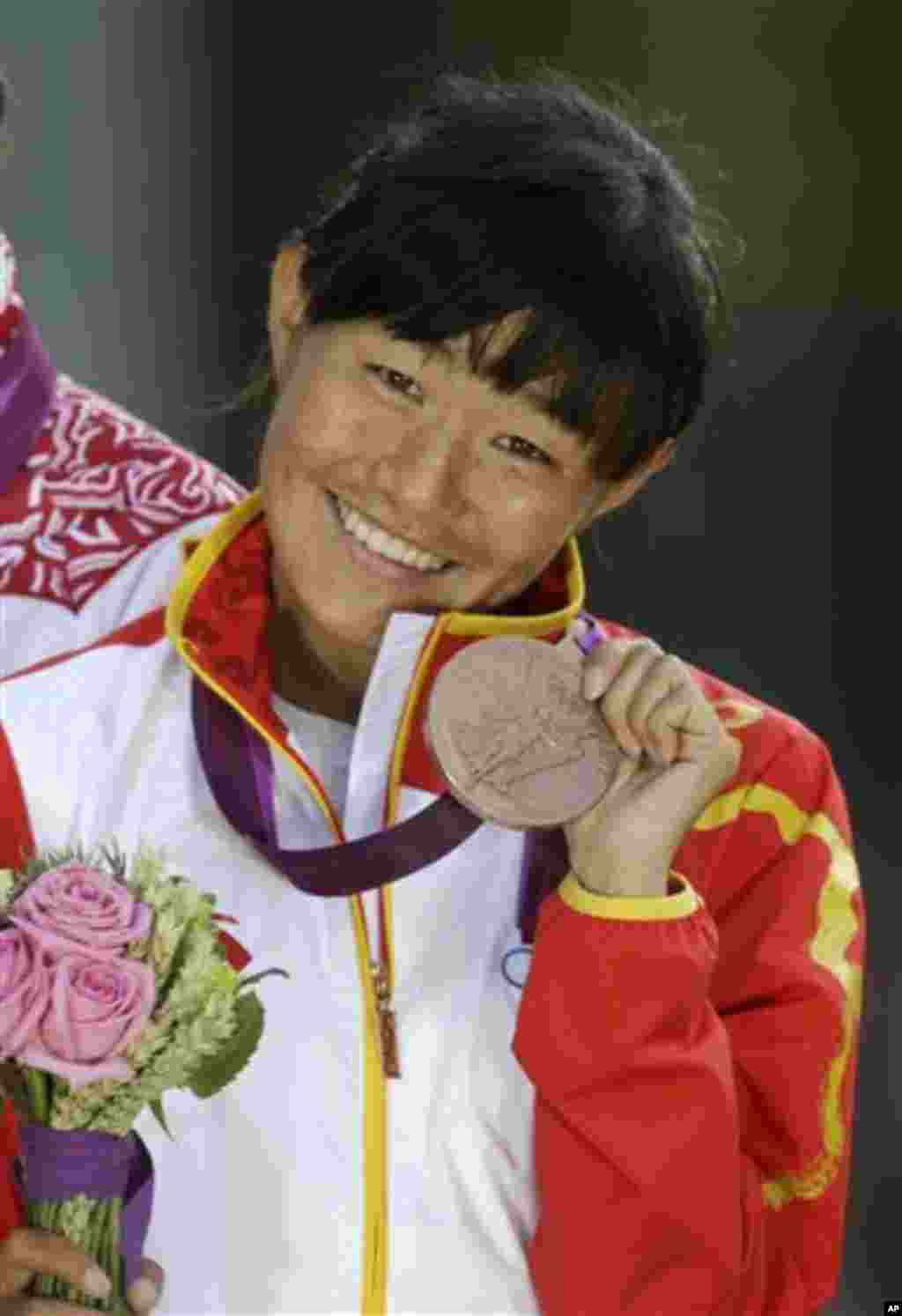 Choeying Kyi poses for photographers after winning the bronze medal in the women's 20-kilometer race walk, at the 2012 Summer Olympics, Saturday, Aug. 11, 2012, in London. 
