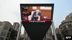 TV program o posjeti bivšeg američkog državnog sekretara Henrija Kisindžera Pekingu emituje se na džinovskom ekranu ispred jednog tržnog centra u Pekingu, 20. jula 2023. (Foto: AFP/Greg Baker)