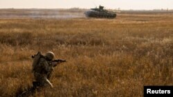 Un miembro de las Fuerzas Armadas de Ucrania participa en simulacros militares en un campo de entrenamiento cerca de la frontera con Crimea anexada a Rusia en la región de Kherson, Ucrania, en este imagen del folleto publicada por el Estado Mayor de las Fuerzas Armad