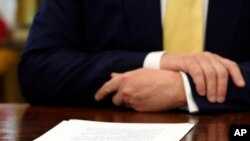 Sebuah dokumen diletakkan di depan Presiden Donald Trump di mejanya di Oval Office Gedung Putih di Washington, 11 Oktober 2019. (Foto: AP)