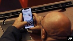 FILE - A Turkish lawmaker checks his mobile phone, in Ankara, Turkey, Jan. 2, 2020. 