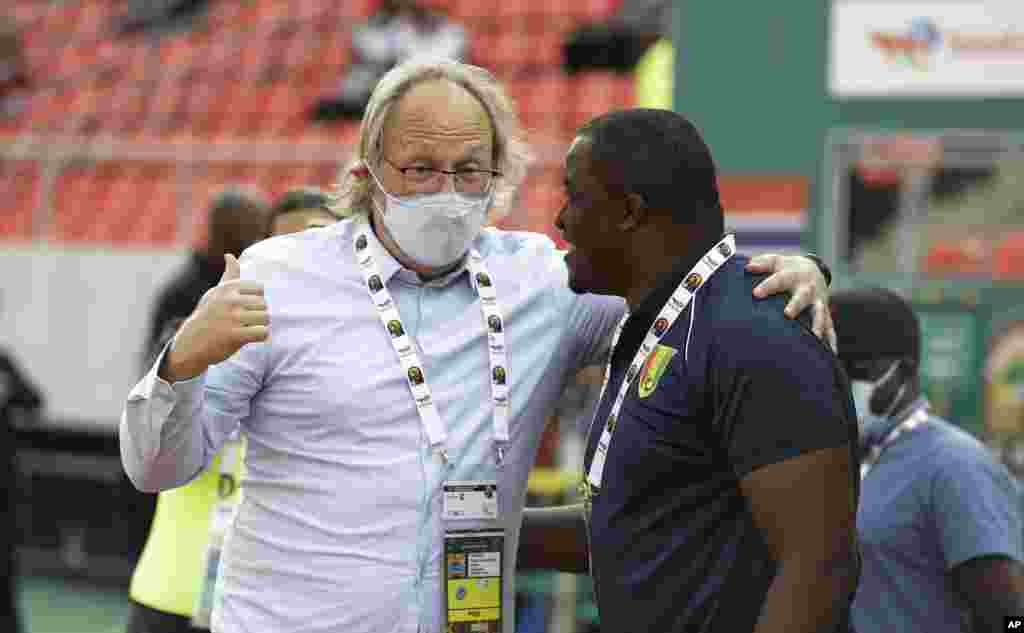 Gambia coach Tom Julianus Saintfiet, left, and Guinea's coach Kaba Diawara before the round of 16 match between Guinea and Gambia in Cameroon, Jan. 24, 2022.