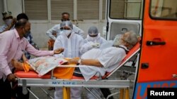 A patient wearing an oxygen mask is wheeled inside a COVID-19 hospital for treatment, amidst the spread of the coronavirus disease (COVID-19) in Ahmedabad, India, Apr. 26, 2021. 