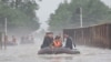 Pemimpin Korea Utara Kim Jong Un (kiri) mengendarai perahu karet melewati banjir saat ia memeriksa kerusakan di wilayah tersebut setelah hujan lebat yang memecahkan rekor pada 29 Juli di Kota Sinuiju di Provinsi Pyongan Utara. (Foto: KCNA VIA KNS/AFP)