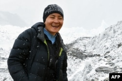لاما 2018 میں ماؤنٹ ایورسٹ کی چوٹی سر کرنے والی خاتون کوہ پیما کا عالمی ریکارڈ بنانے کے ایک دن بعد ایورسٹ کے ایک بیس کیمپ میں فوٹو کےلیے پوز بنا رہی ہیں، ، فائل فوٹو