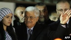 Palestinian president Mahmud Abbas, center, waves to the crowd during a gathering to celebrate the 50th anniversary of the start of the Fatah movement, in the West Bank city of Ramallah, Dec. 31, 2014. 