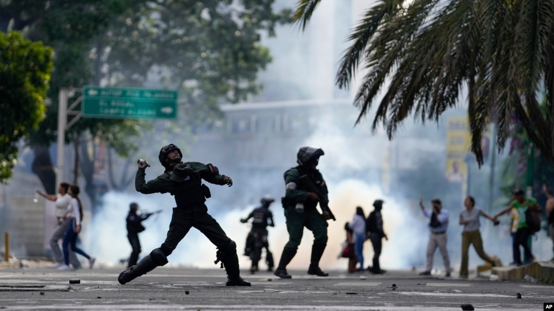 Policías lanzan bombas lacrimógenas contra manifestantes que protestaban los resultados electorales en Venezuela, en Caracas, el 29 de julio de 2024. Según una misión investigadora de la ONU, el gobierno comete crímenes de lesa humanidad en el marco de esa votación. (AP)