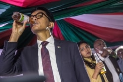 Madagascar's President Andry Rajoelina drinks a sample of the "COVID Organics" or CVO remedy at a launch ceremony in Antananarivo on April 20, 2020. (Photo by RIJASOLO / AFP)