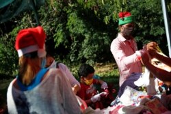 Voluntarios de la iniciativa privada "Santa en las Calles" separan ropa donada para entregar a familias necesitadas en Guarenas, Caracas, el sábado 19 de diciembre de 2020.