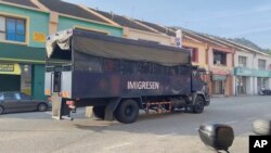 In this image taken from a video, an immigration truck with unidentified people onboard is driven on a road that leads to Lumut Naval Base Tuesday, Feb. 23, 2021 in Lumut, Malaysia.