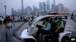 FILE - Police officers patrol Shanghai, China, June 1, 2022.