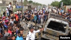 Warga berkumpul di dekat serangan bom di kota Sadr, Baghdad (16/5). Sedikitnya 11 orang tewas dan 18 orang dilaporkan terluka dalam serangan ini.