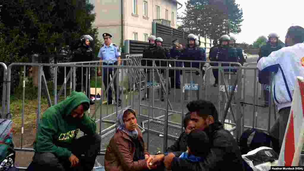 About a dozen Slovenian police guard the tiny border, not flinching when spontaneous protests erupt, at Harmica, Croatia, Sept. 20, 2015.