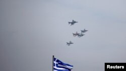FILE - A Greek national flag flutters as a formation of fighter jets fly over Athens, Greece, April 4, 2017. Israel and Greece on Sunday signed their biggest ever defense procurement deal.