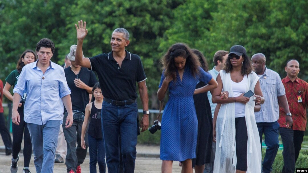 Mantan Presiden AS, Barack Obama, melambaikan tangan saat berjalan bersama putrinya, Mali, dan istrinya Michelle selama kunjungan ke Candi yang berasal dari abad ke-9, Borobudur, di Magelang, Indonesia tanggal 28 Juni 2017 (foto: REUTERS/Pius Erlangga) 