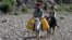 Children ride on donkeys after filling jerry cans with water on the road between Sanaa and Hodeidah, May 16, 2013.