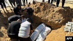 Warga Palestina menguburkan sejumlah jenazah yang tewas akibat serangan udara Israel di Beit Lahia, di utara Jalur Gaza, pada 29 Oktober 2024. (Foto: AFP)