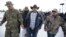 Ammon Bundy, center, one of the sons of Nevada rancher Cliven Bundy, walks off after speaking with reporters during a news conference at Malheur National Wildlife Refuge headquarters, Jan. 4, 2016, near Burns, Ore.