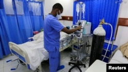 FILE - A health care worker attends to a COVID-19 patient inside the Intensive Care Unit ward equipped with supplemental oxyden, at the Care Hospital, Nairobi, Kenya, Aug. 4, 2021. 
