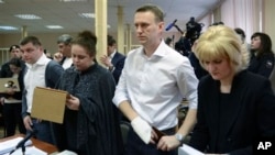 Pemimpin oposisi Rusia Alexey Navalny (dua dari kanan) berdiri saat mendengarkan keputusan hakim di pengadilan Kirov, Rusia (17/4). 