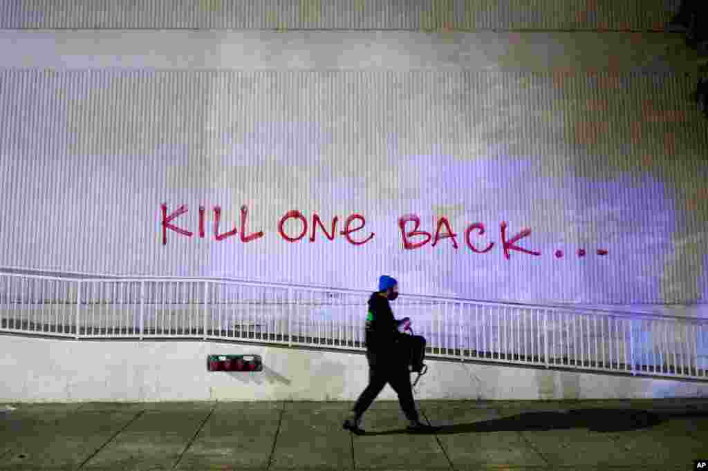 Un manifestante pasa cerca de un grafiti, en Oakland, California, tras protestar por la muerte de George Floyd, el viernes.