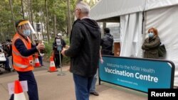 People wait outside a coronavirus disease (COVID-19) vaccination centre at Sydney Olympic Park in Sydney, Australia, July 14, 2021.