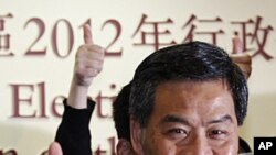 The next Hong Kong Chief Executive Leung Chun-ying celebrates as he attend a news conference at a vote counting station in Hong Kong, March 25, 2012. 