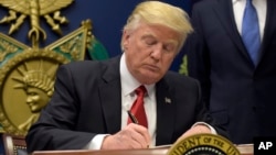 President Donald Trump signs an executive order on extreme vetting during an event at the Pentagon in Washington, Jan. 27, 2017.